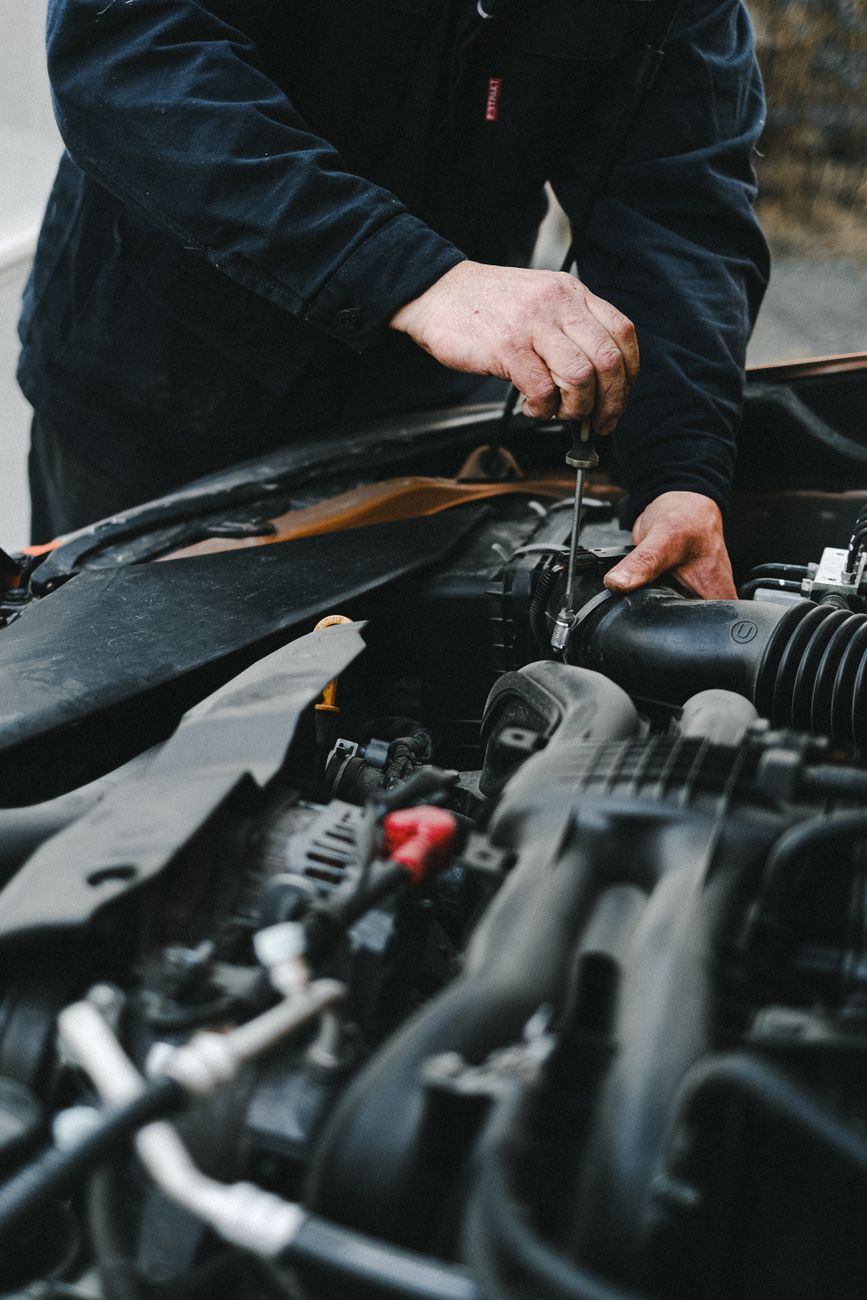 Mekaniker arbejder i motorrummet på en bil